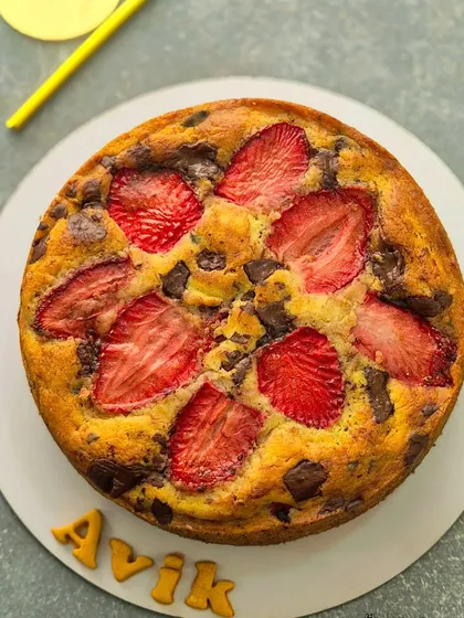 Another look at the strawberry vanilla chocolate chunk cake, ready for a celebration. The name "Avik" is spelled out in edible letters, adding a personal touch.