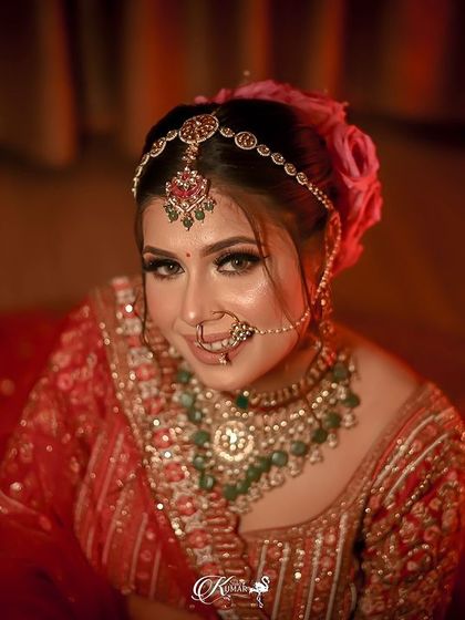 A top-down portrait of a bride in her red lehenga, looking up at the camera.