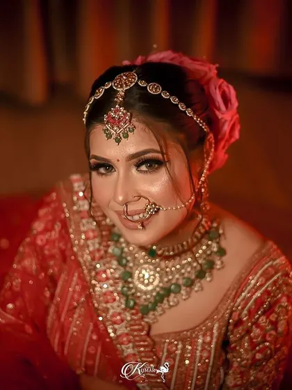 A top-down portrait of a bride in her red lehenga, looking up at the camera.