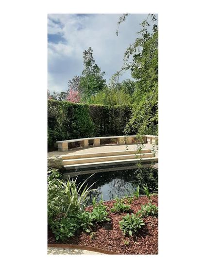 A stone bench provides a destination and a place for rest, overlooking the pond. We believe in creating spaces within the landscape that encourage people to pause and connect with their surroundings.