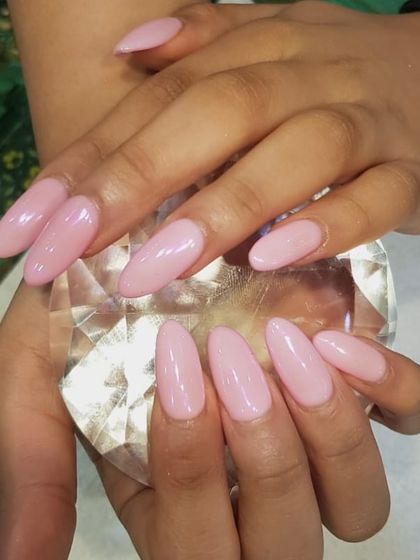 Pink polish perfection. A simple, beautifully applied baby pink gel polish on elegant, almond-shaped nail extensions.