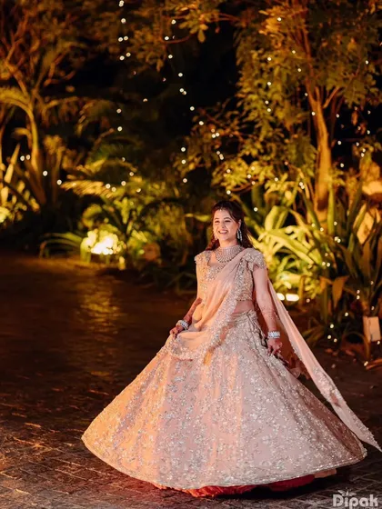 The bride twirling in her magnificent Anushree Reddy lehenga, with the lights creating a magical, sparkling effect.