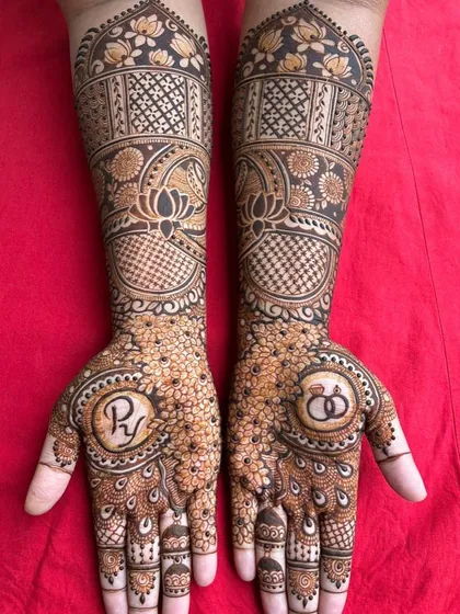 A lovely engagement mehendi design featuring the couple's initials and engagement rings within a floral mandala. It's a beautiful way to celebrate the beginning of a new journey.