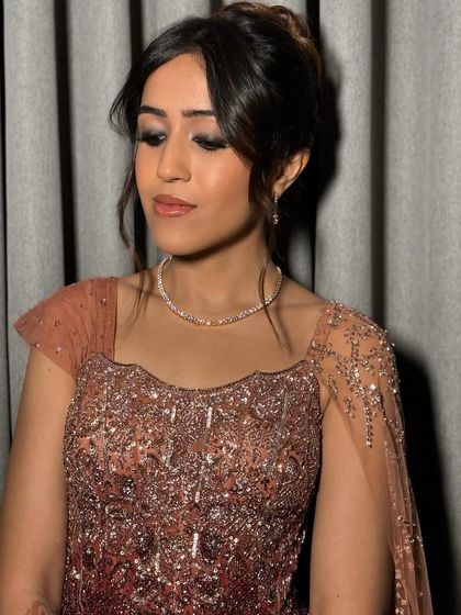 The final look. This messy French twist hairstyle perfectly complements her glamorous sangeet outfit, allowing the intricate details of the dress and her jewelry to shine.