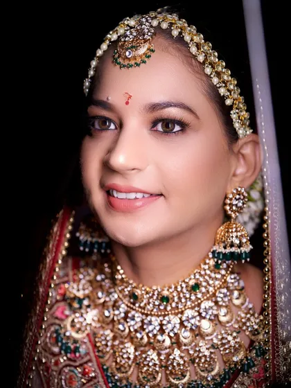 A stunning close-up of the bride, showcasing her intricate jewelry and radiant smile. These portraits are designed to make every bride feel like royalty.