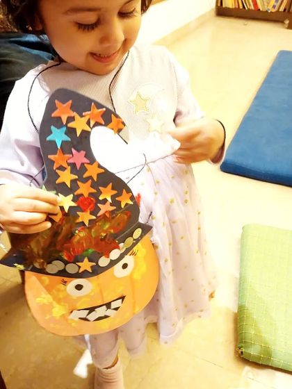 A student looks delighted with the spooky and sparkly Halloween goody bag she created. These workshops are all about combining creativity with festive fun.