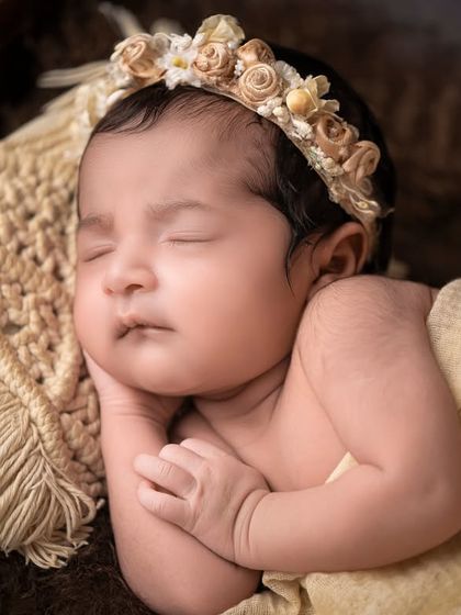 A close-up of a sleeping newborn, highlighting the delicate details of her face.