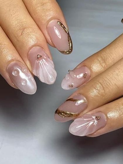 A mermaid-inspired design with a pearlescent base, gold chrome tips, and 3D shell textures.