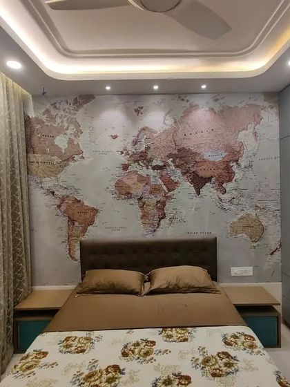 This angle highlights the room's thoughtful lighting design and storage solutions. The ceiling spotlights are positioned to perfectly illuminate the map, while the expansive grey wardrobe offers a clean, seamless look that conceals extensive storage space.