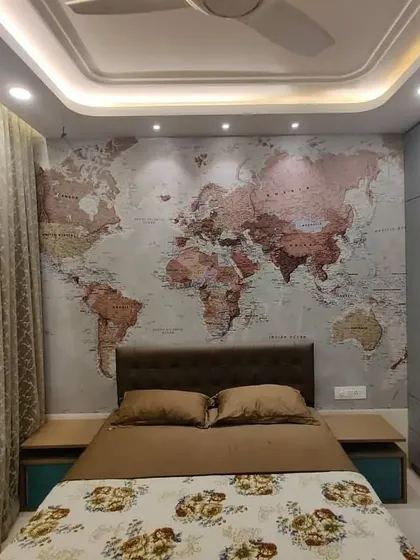 This angle highlights the room's thoughtful lighting design and storage solutions. The ceiling spotlights are positioned to perfectly illuminate the map, while the expansive grey wardrobe offers a clean, seamless look that conceals extensive storage space.