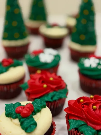 A close-up of my festive Christmas cupcakes. The detailed piping work, including Christmas trees, wreaths, and poinsettias, makes these a special holiday treat.