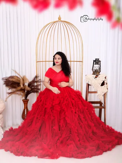A romantic couple's portrait in our bohemian studio setup, with the mother-to-be in a stunning red ruffled gown.