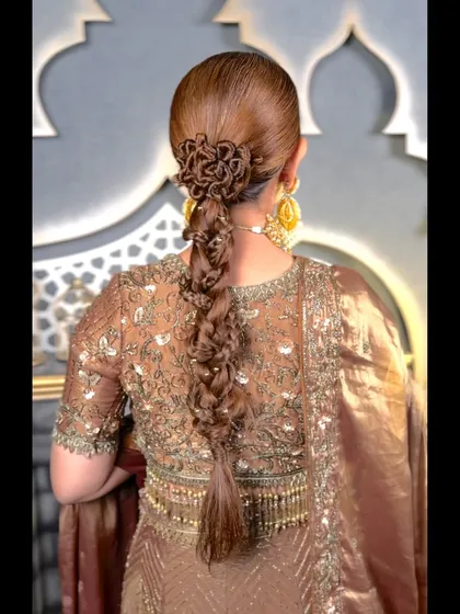 A close-up shot of the intricate floral-patterned braid. This style requires precision and control, skills that we develop through extensive practice during the hairstyling course.