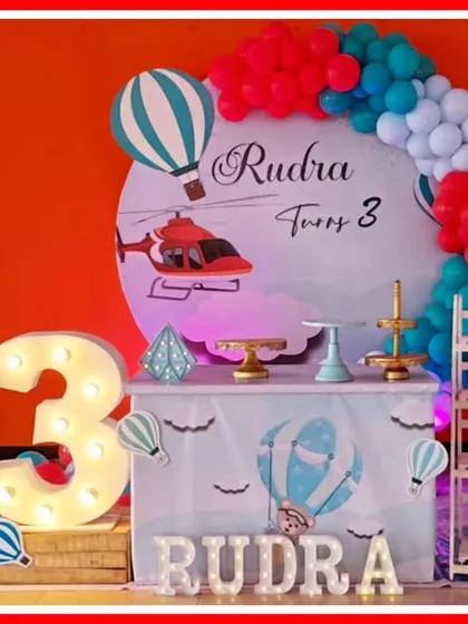 A transportation-themed third birthday, featuring hot air balloons, airplanes, and helicopters in a red and blue color scheme.