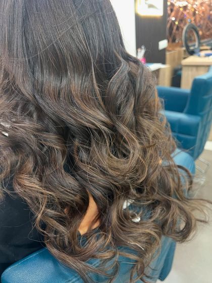 Deep chocolate brown hair with subtle lighter brown pieces woven through. This adds richness and dimension without a dramatic color change.