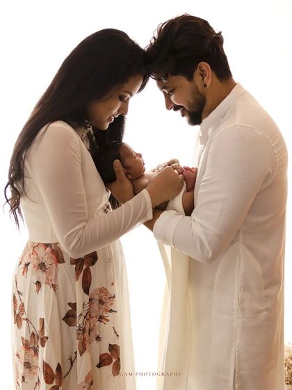 A beautiful family portrait in a high-key style, with the parents dressed in white, creating a fresh, clean, and timeless look.