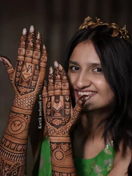 A smiling bride shows off her intricate back-of-hand mehandi, which is filled with sacred symbols for a blessed start to her new life.