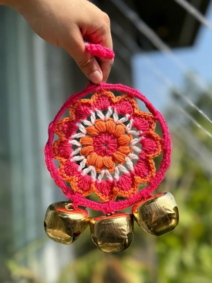 A close-up of our pink and orange ghungroo hanging. The bright colors and the sound of the bells bring a festive spirit to any space.