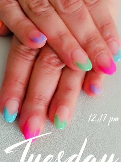 Another look at the rainbow gradient French tips, showing the blend of colors on each nail.