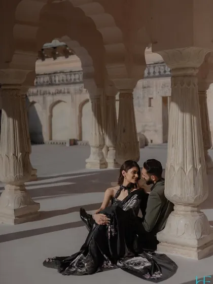 A tender moment shared amidst the majestic pillars of a Rajasthani palace. We seek out these quiet corners within grand locations to capture the personal connection that lies at the heart of your story.