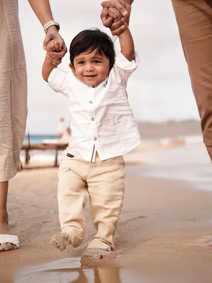 Taking his first steps on the sand with help from mom and dad. We love to document these incredible milestones during our outdoor family beach sessions.