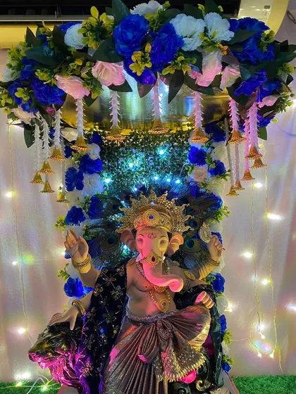 A majestic Ganpati setup featuring a color palette of royal blue and white. I incorporated peacock feathers and hanging bells to add a touch of traditional grandeur to this modern color scheme.