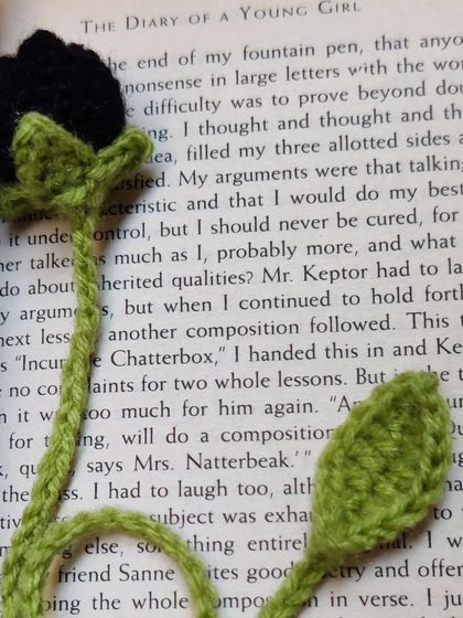 A black tulip bookmark inside a book.