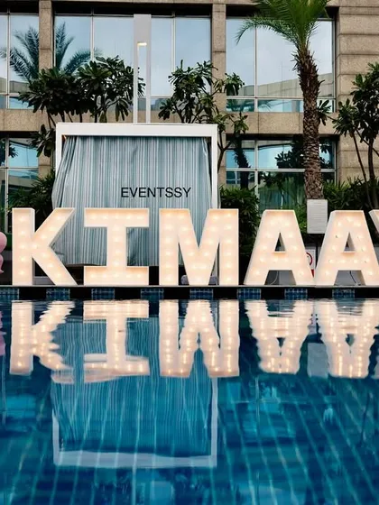 A stunning shot of the birthday girl's name in large marquee letters set up by a pool. The reflection on the water creates a beautiful effect, making it a major statement piece for the carousel-themed event.