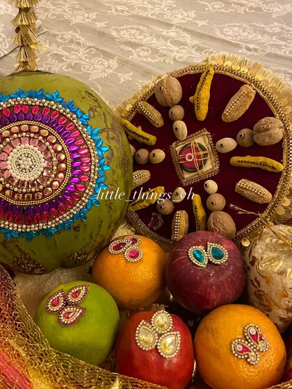 This is our modern take on the traditional 'Oti' blessing basket. It features a coconut decorated with intricate kundan work, alongside embellished fruits, all arranged to bring blessings of prosperity and abundance to the mom-to-be or new bride.