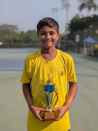 Aarav Chhallani proudly holding his U-16 doubles winner's trophy.