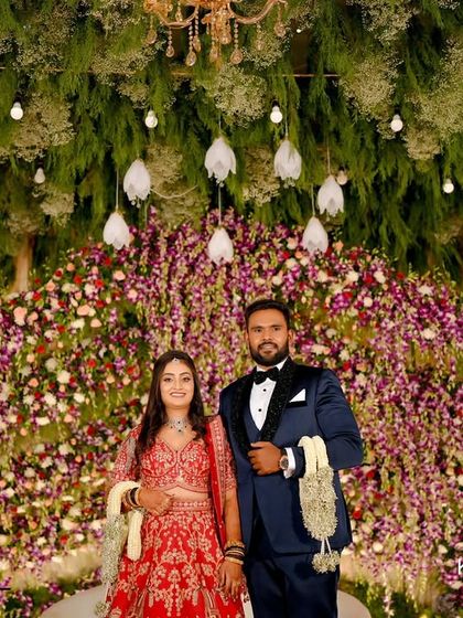 A grand reception stage with a backdrop of cascading orchids and baby's breath, creating a lush, garden-like feel indoors.