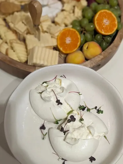 Fresh burrata cheese, delicately torn open and garnished with microgreens. This simple, high-quality offering was a highlight at the Paul Smith event.