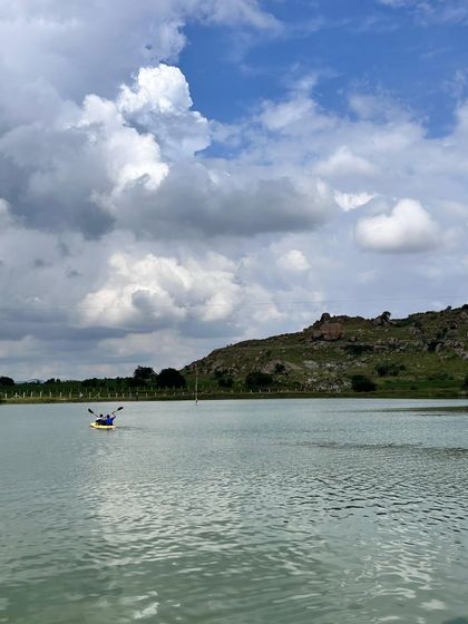 A wide shot of a kayaker on the lake, showing the scale and beauty of the location.