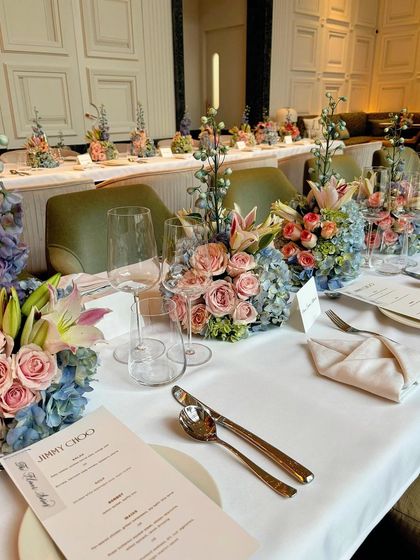 Another perspective of the elegant dining experience crafted for Jimmy Choo, with soft lighting enhancing the beauty of the floral decor.
