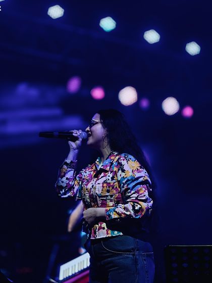 A solo shot of me singing under the stage lights. The bokeh effect in the background shows the beautiful lighting production we bring to our concerts.