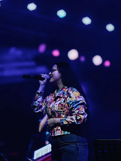 A solo shot of me singing under the stage lights. The bokeh effect in the background shows the beautiful lighting production we bring to our concerts.