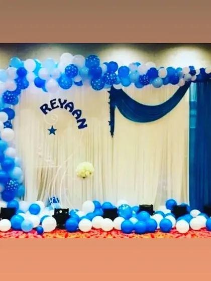 A classic and clean birthday backdrop in shades of blue and white. This simple yet elegant setup features a balloon arch and personalized name cutout, perfect for any celebration.