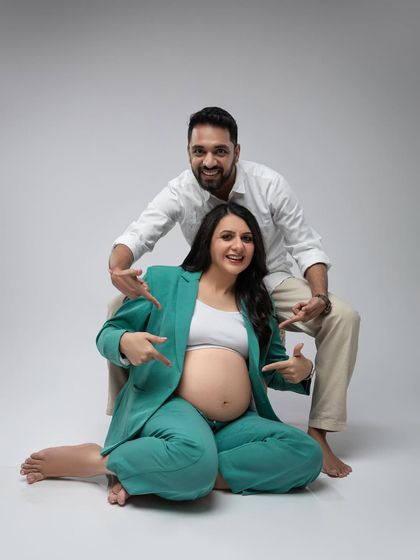 A fun and playful shot, with both parents-to-be pointing at the star of the show.