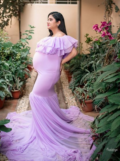 A profile shot that accentuates the beautiful baby bump, with the lush garden providing a soft, natural background.
