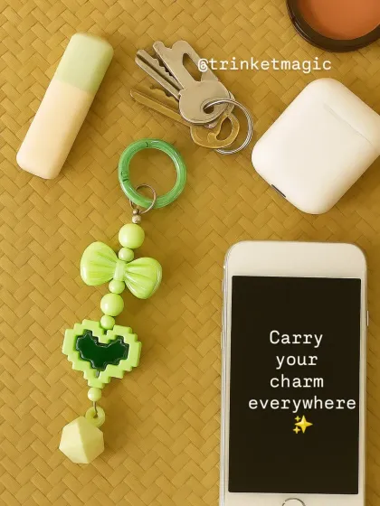 Carry your charm everywhere. This flat lay shows how my mint pixel heart charm can be used as a keychain, keeping your essentials like keys, phone, and AirPods stylishly together.