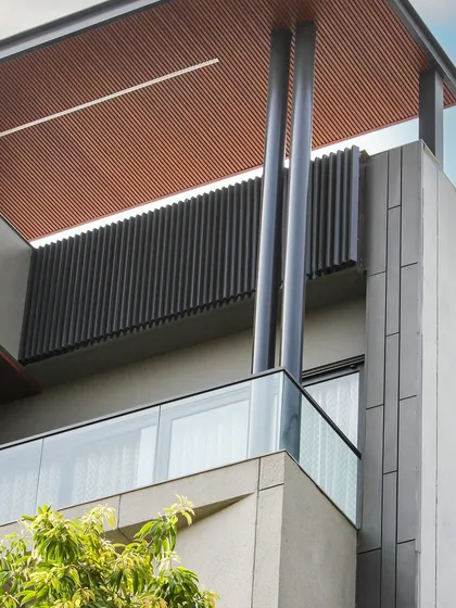 A close-up of the Akashneem Marg project, highlighting the strong vertical columns and the texture of the wood-look ceiling panels. The design is simple, modern, and sophisticated.