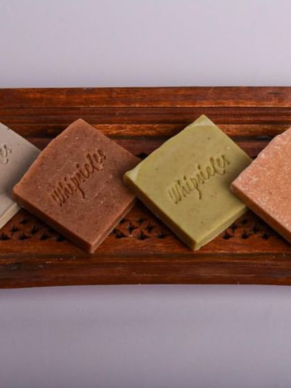 Our Everyday Essentials Trial Pack laid out on a wooden tray. This set includes four of our most popular soaps: Salt Spa Bar, Green Zest, Floral Bliss, and Blue Musk, perfect for sampling or gifting.