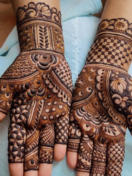 For those who love dense and detailed work, this design fills the entire palm with a variety of intricate patterns. It combines geometric shapes, dots, and leafy motifs for a truly captivating effect.