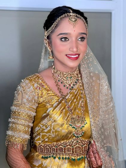 A portrait of the happy bride, glowing after her makeover. The makeup is classic and elegant, perfect for her Muhurtham.