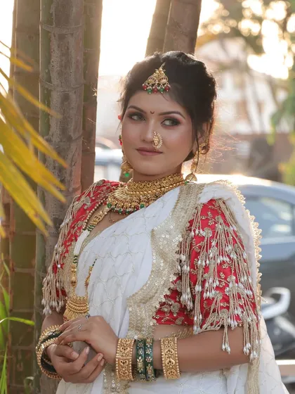 A beautiful profile of the bride, highlighting the intricate details of her blouse and jewellery. The makeup is flawless from every angle.