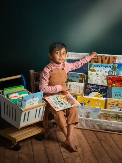 For my son's fifth birthday, we celebrated his love for books. This whimsical studio setup, with a floating book and a library of his favorites, is a portrait of his growing imagination.