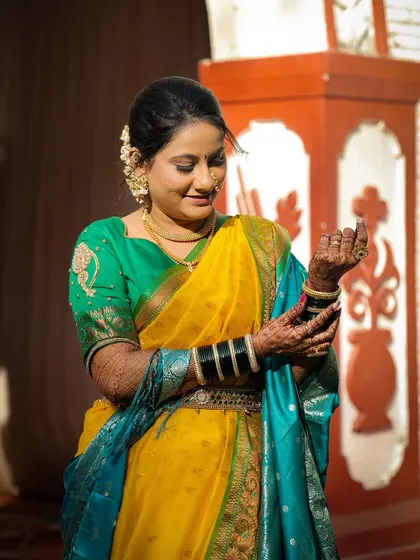 The bride posing gracefully, showing off her full look. The yellow and green saree is a classic choice, and her makeup is flawless.