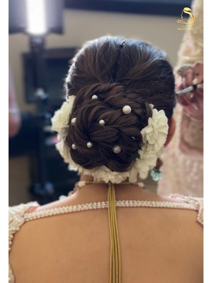 A detailed shot from the back, showcasing the beautiful texture and placement of pearls within the floral bun.