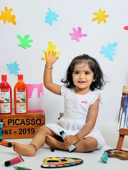 A happy wave from our little painter. The bright colors and her joyful expression make this a wonderfully energetic and happy photograph.