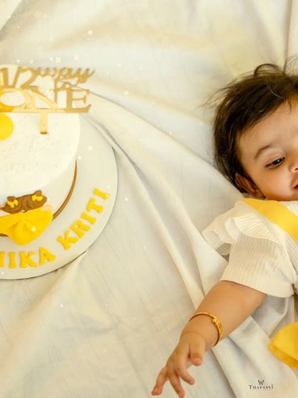 A close-up of the half-birthday girl and her personalized cake, capturing her sweet expression.